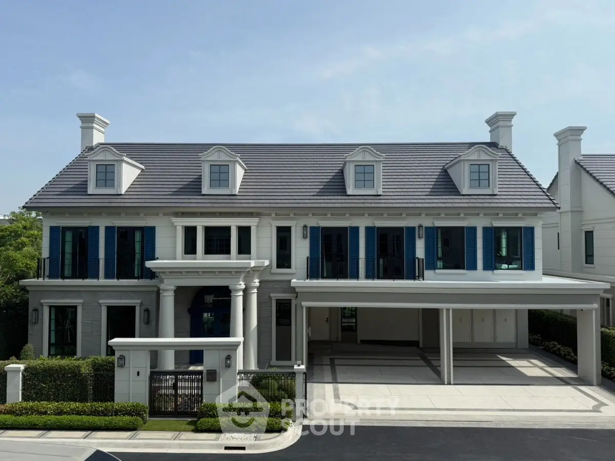 Luxurious colonial-style mansion with spacious driveway and elegant facade.