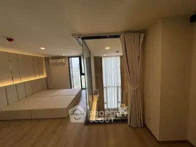 Modern apartment with spacious living area and city view, featuring floor-to-ceiling windows and elegant decor.