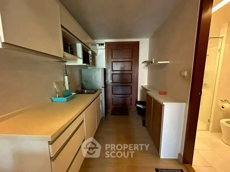 Modern kitchen with sleek cabinetry and compact design, featuring stainless steel appliances and ample counter space.