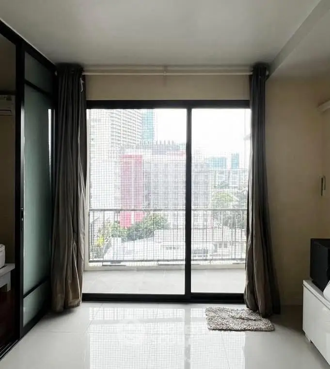Modern apartment with large windows and city view, featuring sleek interior design and ample natural light.