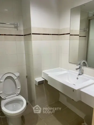 Modern bathroom with sleek white fixtures and tiled walls, perfect for a contemporary home.