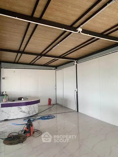 Spacious commercial interior with modern ceiling and marble reception desk, ideal for business setup.