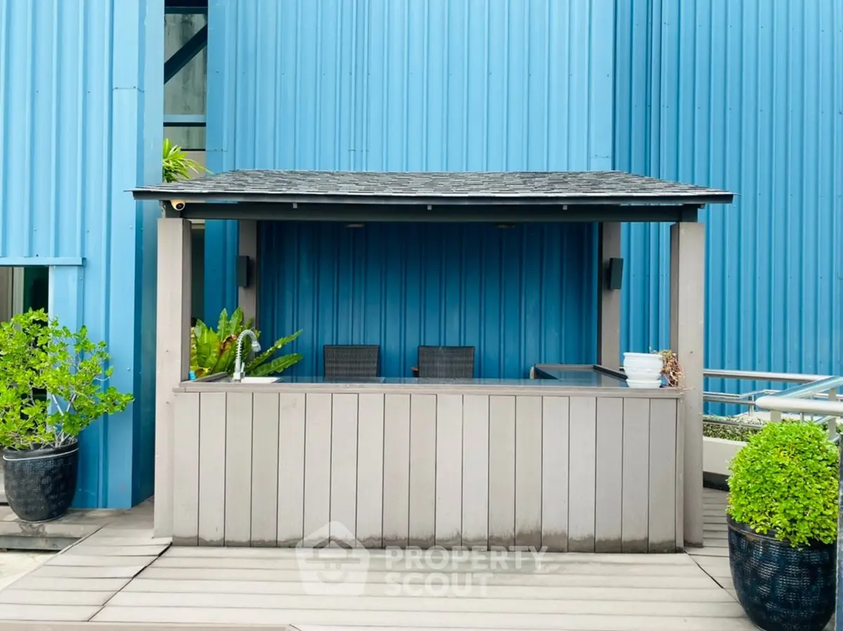 Charming outdoor bar area with modern design and lush greenery, perfect for entertaining guests.
