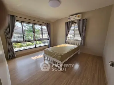 Spacious bedroom with large windows and natural light in modern home