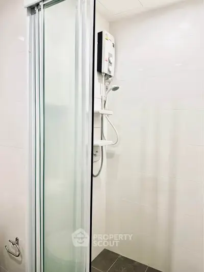 Modern bathroom shower with sliding glass door and electric water heater
