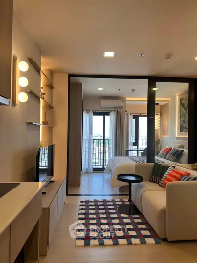 Modern open-plan living room with stylish decor and cozy bedroom view