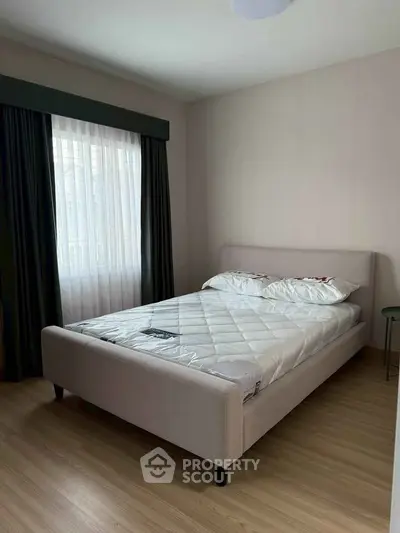 Cozy bedroom with natural light and modern furnishings, perfect for relaxation and comfort.