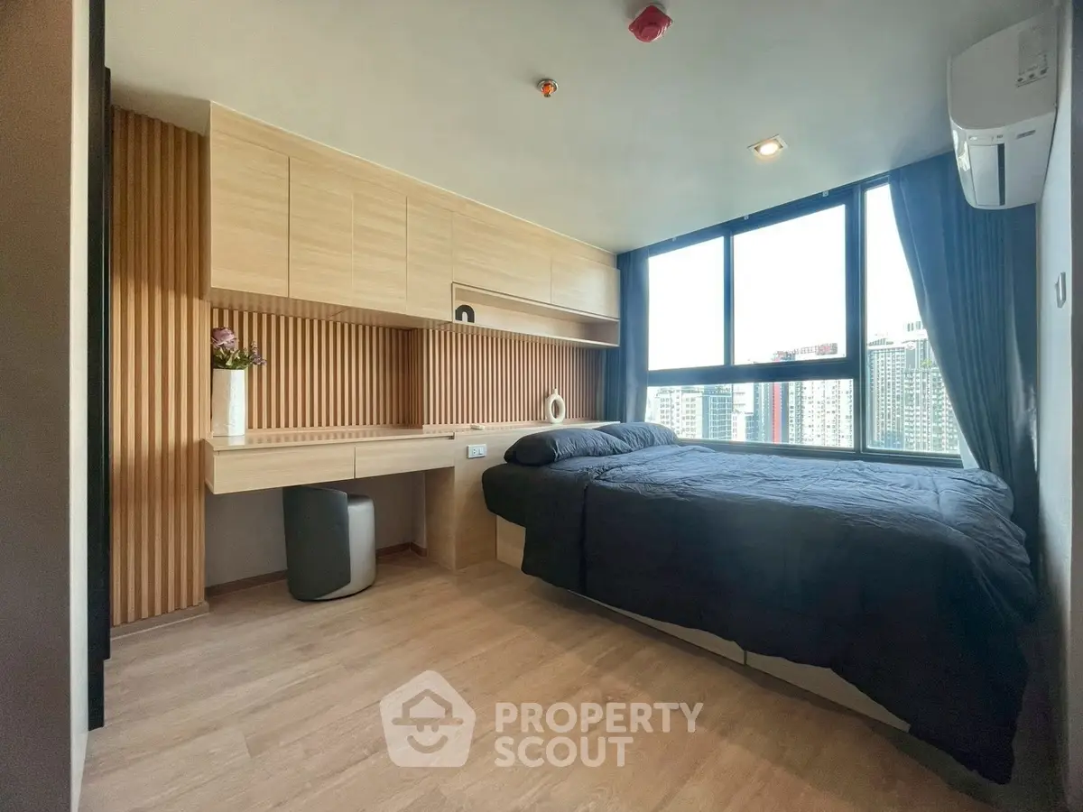 Modern bedroom with large window and wooden accents in urban apartment