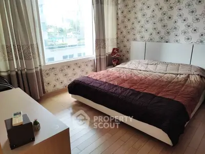 Cozy bedroom with modern decor and large window offering natural light