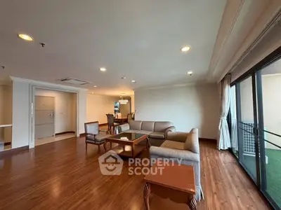Spacious living room with elegant wooden flooring and large windows for natural light.