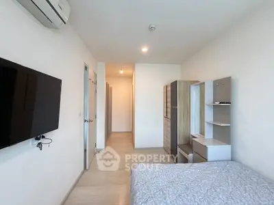 Modern bedroom with sleek design, featuring a wall-mounted TV and ample storage space.
