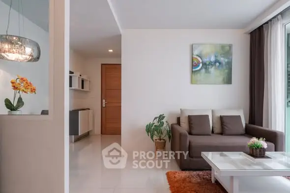 Modern living room with cozy sofa, stylish decor, and natural light from large window.