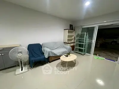 Spacious living room with modern furniture and sliding glass doors leading to outdoor area.