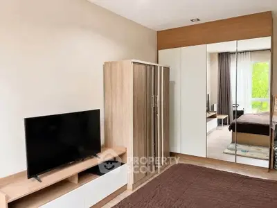 Modern bedroom with mirrored wardrobe and TV unit, featuring a cozy and inviting atmosphere.