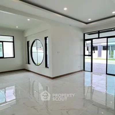 Spacious modern living room with large windows and glossy tile flooring