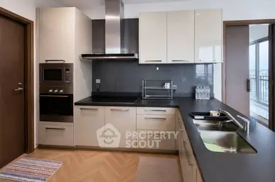 Modern kitchen with sleek cabinetry and built-in appliances, featuring a spacious countertop and stylish design.