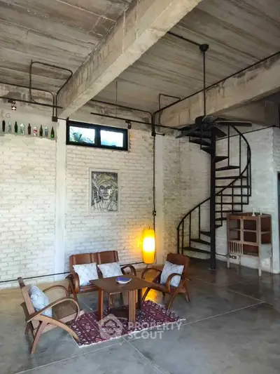 Stylish industrial loft with spiral staircase and cozy seating area.