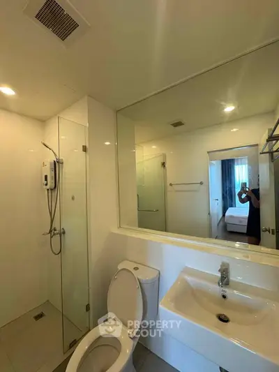 Modern bathroom with glass shower and sleek fixtures in a contemporary apartment.