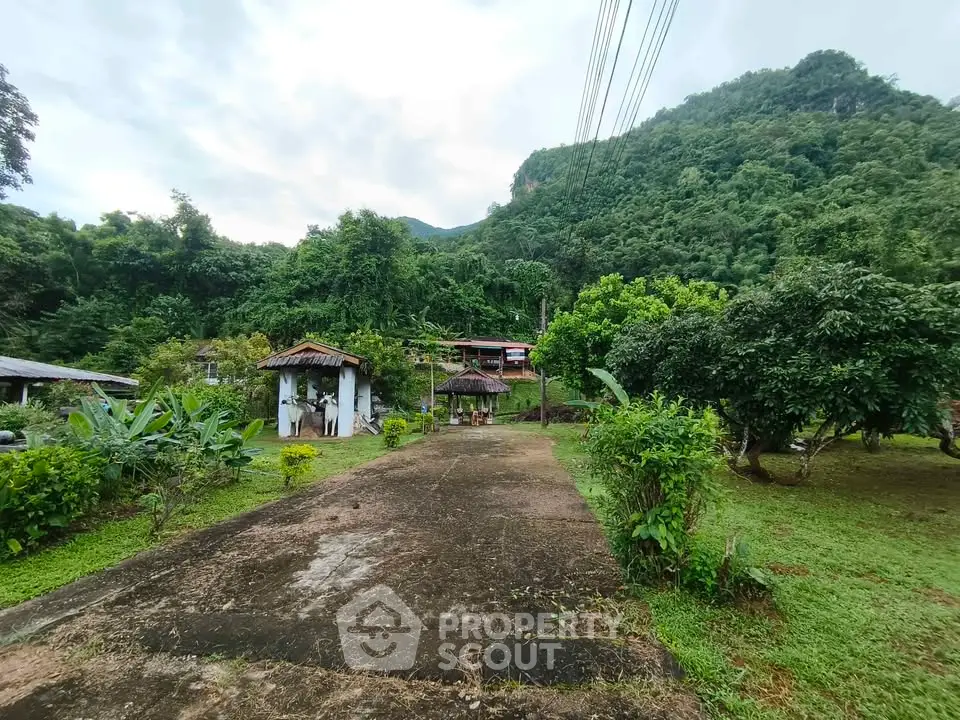 Scenic view of lush green landscape with rustic buildings and mountain backdrop, perfect for nature lovers.