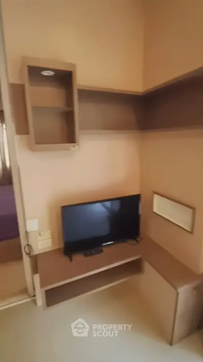 Cozy corner with TV and shelving in modern apartment