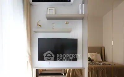 Modern bedroom with wall-mounted TV and stylish decor in a cozy apartment.