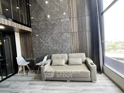 Modern living room with stylish sofa and large windows offering a stunning city view.