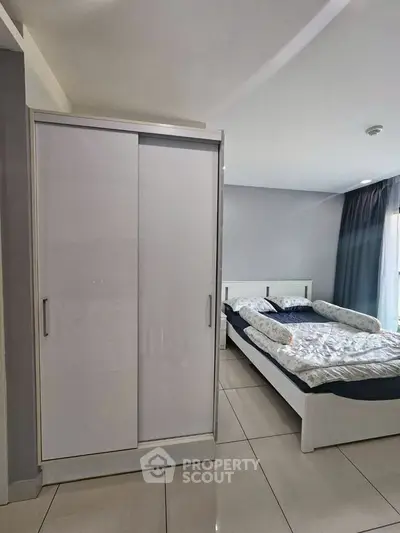 Modern bedroom with sleek white wardrobe and cozy bed, perfect for a comfortable living space.