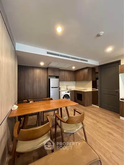 Modern kitchen and dining area with wooden furniture and built-in appliances