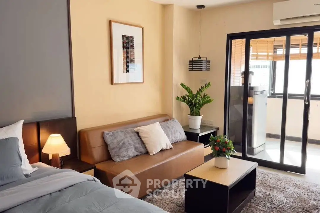 Modern studio apartment with cozy living area and balcony access