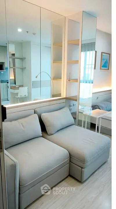 Modern living room with stylish sofa and mirrored wall in a bright apartment