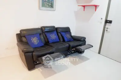 Modern living room with black leather recliner sofa and stylish decor.