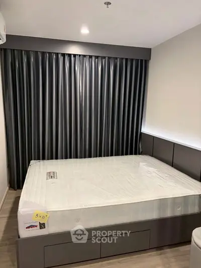 Modern bedroom with sleek design and large bed, featuring stylish dark curtains and ambient lighting.