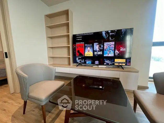 Modern living room with stylish furniture and large TV, perfect for entertainment and relaxation.