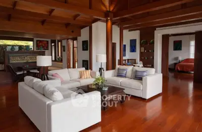Luxurious open-plan living room with elegant wooden flooring and modern decor