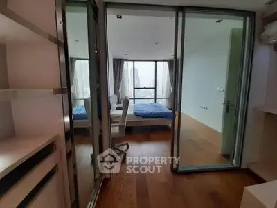 Modern bedroom with wooden flooring and large windows offering city views.