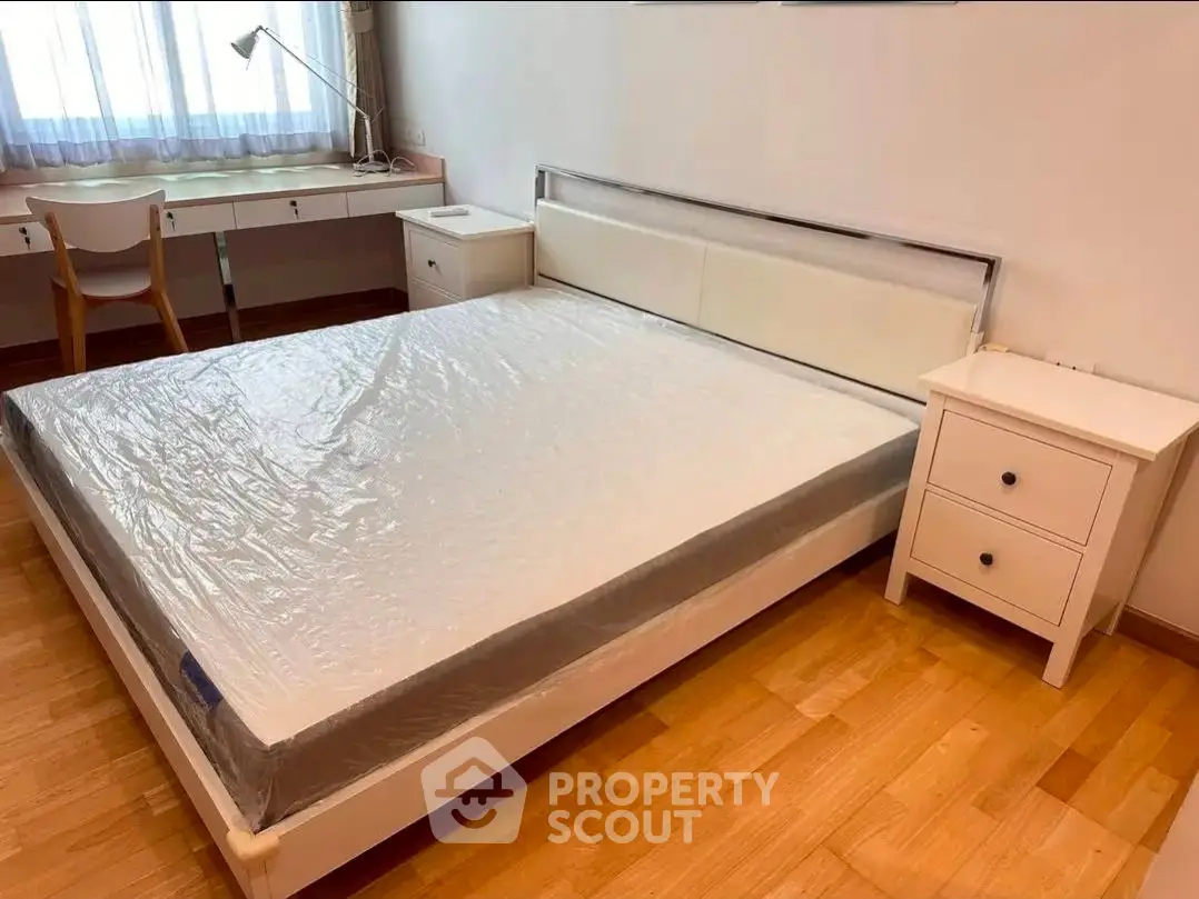 Spacious bedroom with modern furniture and natural light, perfect for relaxation and comfort.