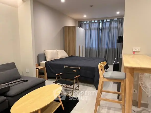 Modern studio apartment with cozy living area and stylish furnishings.