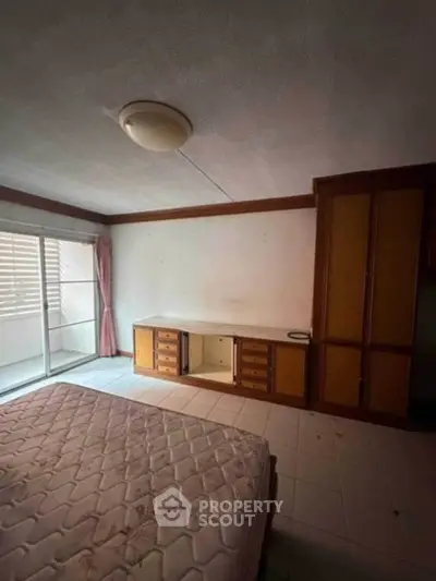 Spacious bedroom with balcony access and built-in wardrobe, ideal for comfortable living.