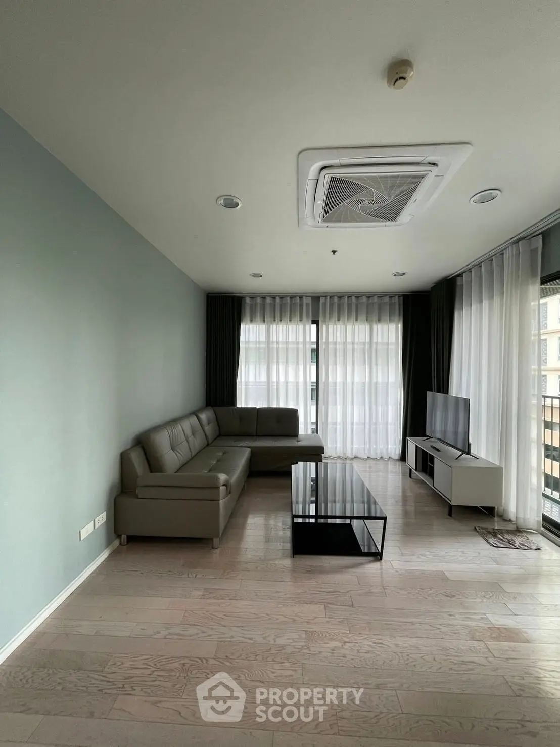 Spacious modern living room with sleek furniture and large windows for natural light.