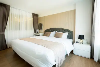 Luxurious bedroom with elegant decor and large windows for natural light.