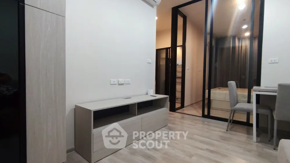 Modern minimalist living room with sleek furniture and glass partition in a stylish apartment.