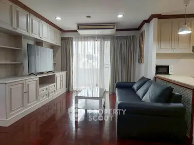 Spacious living room with modern furnishings and large TV in a stylish apartment.