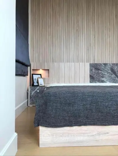 Modern bedroom with stylish wood paneling and cozy bedding