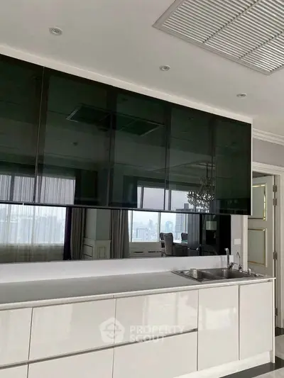 Modern kitchen with sleek cabinetry and integrated sink, featuring a stylish open layout and large windows.