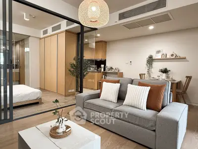 Modern open-plan living room with cozy decor and adjacent bedroom view