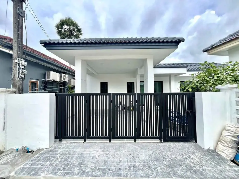 Modern single-story house with sleek black gate and minimalist design.
