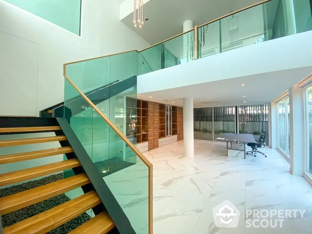 Luxurious multi-level home interior with marble flooring, modern glass railing staircase, and expansive open-plan living space, perfect for upscale urban living.