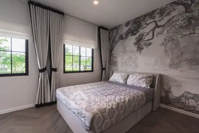 Stylish bedroom with scenic wallpaper and large windows offering natural light.