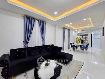 Luxurious modern living room with elegant black sofa and dining area