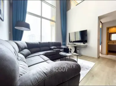 Spacious living room with large windows and modern sectional sofa